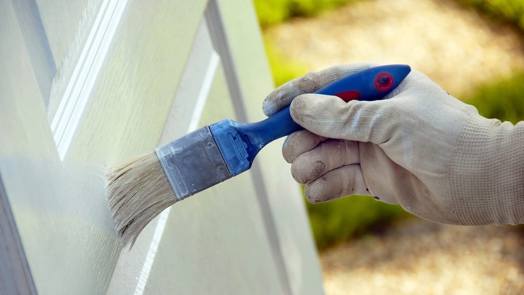 Person using paintbrush to apply primer