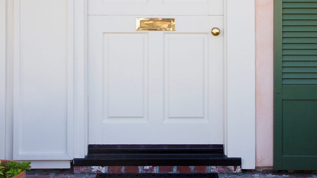 white exterior door with door sweep
