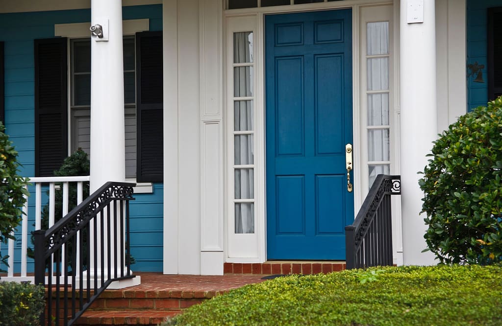 Vibrant blue front door on a traditional home exterior, a bold example for those choosing a front door color to enhance curb appeal.