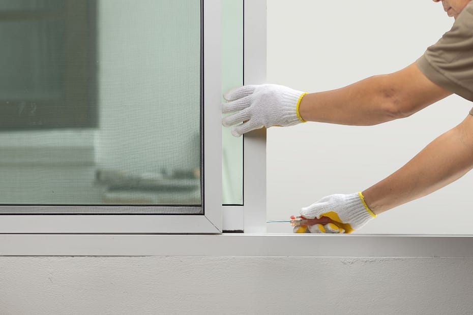 Fixing a window frame, showing how maintenance affects how long do windows last.